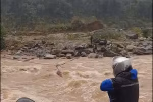 Lực lượng chức năng dùng dây cáp cố định vị trí và dùng tời để di chuyển người qua sông. 