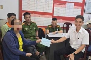 Lực lượng Công an và nhân viên ngân hàng làm thủ tục trao tiền lại cho bà P. Ảnh: CACC
