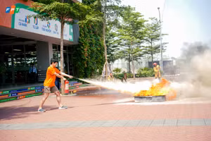 Học sinh học cách dùng bình chữa cháy mini để dập lửa. 