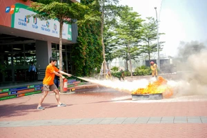 Học sinh học cách dùng bình chữa cháy mini để dập lửa.