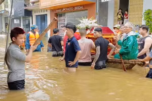Ông Nguyễn Ngọc Minh (mặc áo mưa xanh) cùng Công an, Bộ đội và người dân chở linh cữu cụ Đối ra nơi cao để đi an táng.