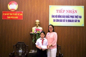 Em Bảo Quyên trao tiền quyên góp ủng hộ đồng bào bị ảnh hưởng của mưa lũ. 