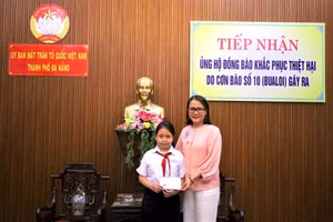 Em Bảo Quyên trao tiền quyên góp ủng hộ đồng bào bị ảnh hưởng của mưa lũ. 