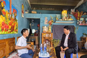 Ông Lê Công Quang (bên trái) kể lại lúc cứu 2 trẻ bị đuối nước ở biển Nam Ô.