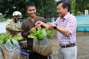 Ông Trần Quốc Huy - Chủ tịch UBND xã Tu Mơ Rông trao món quà cho bà con.
