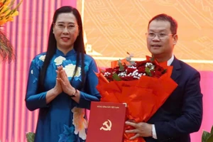 Bà Bùi Thị Quỳnh Vân, Phó Trưởng ban Tổ chức Trung ương trao quyết định và tặng hoa chúc mừng ông Nguyễn Mạnh Hùng. Ảnh: Đ.N