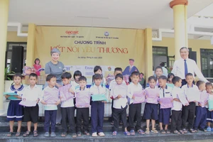 Nhà báo Dương Thanh Hương - Phó Tổng Biên tập Báo GD&TĐ và ông Mai Tấn Linh - Phó Giám đốc Sở GD&ĐT TP Đà Nẵng trao quà cho học sinh.