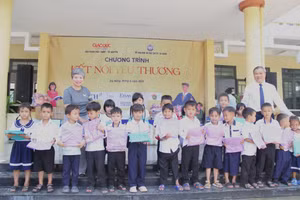 Nhà báo Dương Thanh Hương - Phó Tổng Biên tập Báo GD&TĐ và ông Mai Tấn Linh - Phó Giám đốc Sở GD&ĐT TP Đà Nẵng trao quà cho học sinh.