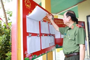 Thiếu tướng Nguyễn Hữu Hợp, Giám đốc Công an TP Đà Nẵng kiểm tra bảng niêm yết danh sách cử tri tại điểm bỏ phiếu bầu cử. Ảnh: CAĐN