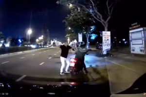 Người đàn ông cầm mũ bảo hiểm hành khung tài xế GrabBike.