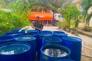 Bộ đội cung cấp nước sạch hỗ trợ người dân vùng lũ. 