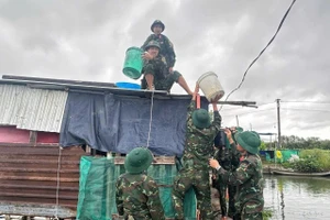 Cán bộ chiến sĩ Sư đoàn 2 (Quân khu 5) khẩn trương gia cố chằng chống nhà cửa cho dân.