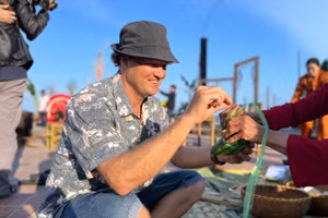 Du khách trổ tài gói bánh chưng.