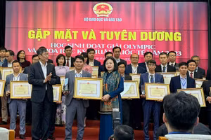 Thầy giáo Đỗ Văn Nhỏ nhận giấy khen của Bộ GD&ĐT trong lễ tuyên dương học sinh đoạt giải Olympic và khoa học kỹ thuật quốc tế năm 2023. 