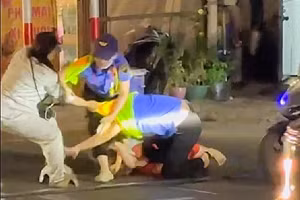 Người phụ nữ hành hung nhân viên gác chắn, mặc cho người khác can ngăn. Ảnh cắt từ clip