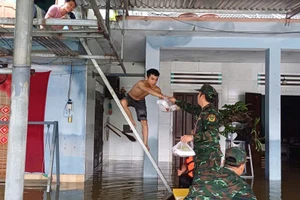 Cán bộ, chiến sĩ Cục Chính trị Quân khu 5 trao cơm cho người dân vùng lũ. 