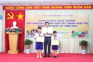 Ông Trần Thanh Bình, Giám đốc Sở GD&ĐT TP Cần Thơ trao giải Nhất cho đội HS đoạt giải.