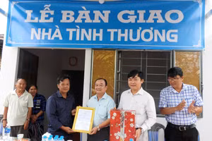 Ông Lê Văn Liêm - Chủ tịch UBND xã Phú Quới (huyện Long Hồ, tỉnh Vĩnh Long) trao quyết định bàn giao nhà cho gia đình ông Dương Thanh Nhã.