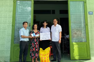 Đại diện Ban Giám hiệu Trường THPT Phan Văn Trị và Đảng ủy xã Mỹ Khánh trao cho gia đình em Danh Trần Quốc Kiệt số tiền 41.557.000 đồng.