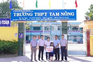 Đại diện Trường ĐH Đồng Tháp trao tặng số tiền động viên, tiếp sức hai chị em Trương Thị Nhu Mỹ.