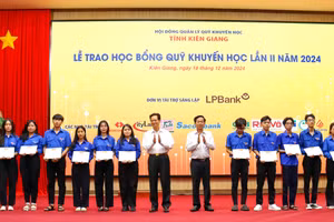 Nguyên Ủy viên Bộ Chính trị, Nguyên Thủ tướng Chính phủ Nguyễn Tấn Dũng và Bí thư Tỉnh ủy Đỗ Thanh Bình trao học bổng hỗ trợ cho sinh viên.