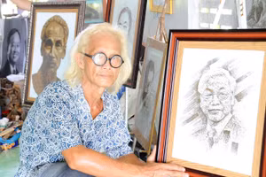 Nghệ nhân Bảy Nghĩa bên bức tranh chân dung Tổng Bí thư Nguyễn Phú Trọng làm từ lá sen.