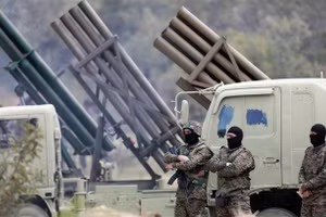 Các chiến binh Hezbollah đứng cạnh dàn phóng tên lửa. 