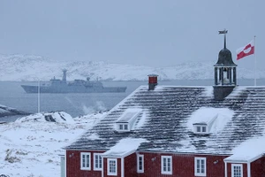 Lá cờ Greenland tung bay trên một tòa nhà khi tàu khu trục của Hải quân Đan Mạch tuần tra tại Nuuk, Greenland.