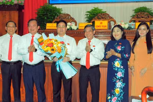 Lãnh đạo Tỉnh ủy, HĐND, UBND tỉnh Hậu Giang chúc mừng ông Trần Văn Huyến (cầm hoa). (Ảnh: C.K)