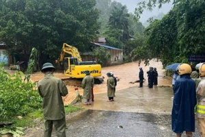 Chính quyền địa phương huy động máy móc khơi thông cống rãnh, giúp người dân vùng lũ.