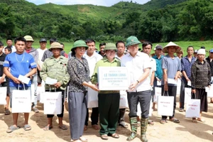 Phó Thủ tướng Lê Thành Long (người đầu tiên từ phải sang, hàng thứ nhất) tặng quà hỗ trợ người dân bị thiệt hại.
