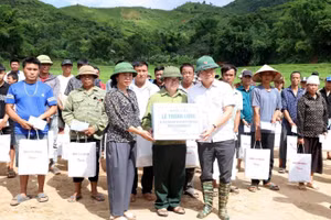 Phó Thủ tướng Lê Thành Long (người đầu tiên từ phải sang, hàng thứ nhất) tặng quà hỗ trợ người dân bị thiệt hại.