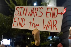 Một người biểu tình Israel cầm biển hiệu nói về cái chết của thủ lĩnh Hamas, ngày 17/10/2024