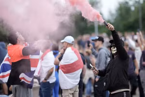 Những người biểu tình phản đối di cư giơ pháo sáng biểu tình bên ngoài một khách sạn nơi trú ngụ của những người xin tị nạn ở Rotherham, Anh, ngày 4/8/2024 