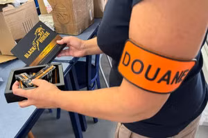 Một quan chức hải quan Pháp chụp ảnh với sản phẩm "mật ong kích thích tình dục" bị thu giữ.