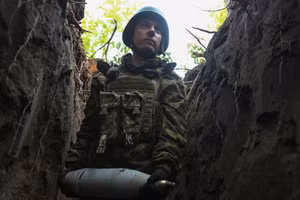 Binh sĩ Ukraine mang theo một quả đạn pháo trên tuyến đầu ở vùng Donestk.