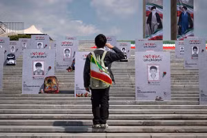 Một học sinh Iran đứng trước những bức chân dung của các em nhỏ thiệt mạng trong vụ không kích Minab của Mỹ và Israel, ngày 1/4/2026.