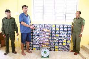 Trần Văn Nguyện (giữa) cùng tang vật.