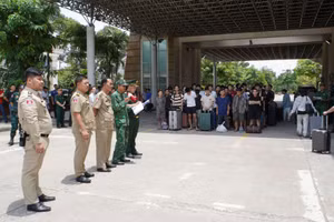 Lực lương chức năng Việt Nam và Campuchia làm thủ tục bàn giao, tiếp nhận công dân được trao trả. (Ảnh: Bộ Công an)