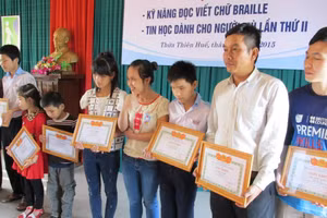 Các người khiếm thị TP Huế nhận bằng khen ở lễ tổng kết lớp học kỹ năng đọc viết chữ Braille.