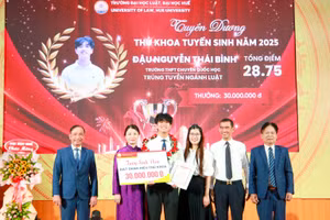 Đậu Nguyễn Thái Bình nhận học bổng, chụp ảnh lưu với lãnh đạo Trường Đại học Luật, Đại học Huế và gia đình tại Lễ khai giảng năm học mới. (Ảnh: Hoàng Hải)