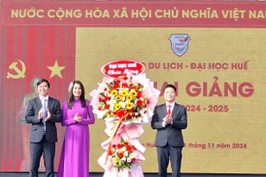 TS Bùi Văn Lợi, Phó Giám đốc Đại học Huế (bìa phải) tặng hoa chúc mừng Ban Giám hiệu Trường Du lịch - Đại học Huế tại lễ khai giảng. (Ảnh: Đại Dương)