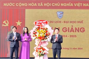 TS Bùi Văn Lợi, Phó Giám đốc Đại học Huế (bìa phải) tặng hoa chúc mừng Ban Giám hiệu Trường Du lịch - Đại học Huế tại lễ khai giảng. (Ảnh: Đại Dương)