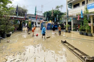 Các thầy cô giáo dọn bùn đất sau lũ tại sân trường Tiểu học Phú Bình, phường Phú Xuân chiều 30/10.