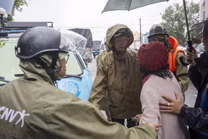 Ông Phan Thiên Định, Chủ tịch UBND TP Huế (giữa) động viên các bệnh nhân được đưa ra từ Bệnh viện Phục hồi chức năng (phường Phú Xuân) đang ngập sâu để di chuyển đến nơi an toàn.