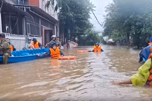 Công an TP Huế đi ghe đến các hộ dân nhà thấp trũng đưa đi tránh lũ.
