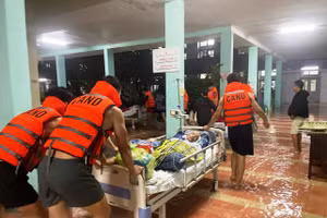 Các chiến sĩ công an xuyên đêm giúp vận chuyển bệnh nhân lên cao tại bệnh viện bị ngập lũ.