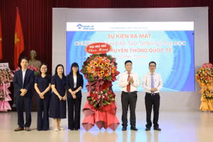 Lãnh đạo Đại học Huế (phải) tặng hoa chúc mừng lãnh đạo Trường Đại học Ngoại ngữ, Đại học Huế (bên trái) tại buổi lễ.