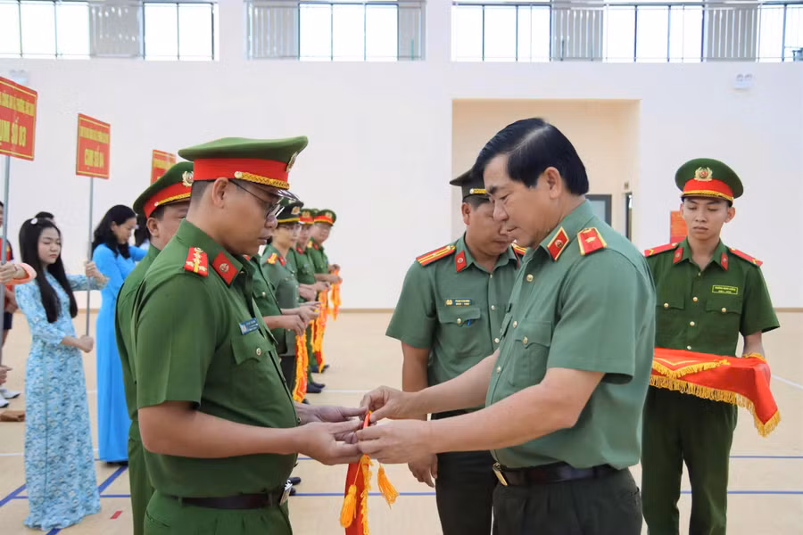 Thiếu tướng Nguyễn Văn Hận, Giám đốc Công an tỉnh An Giang, trao cờ lưu niệm cho các đơn vị.