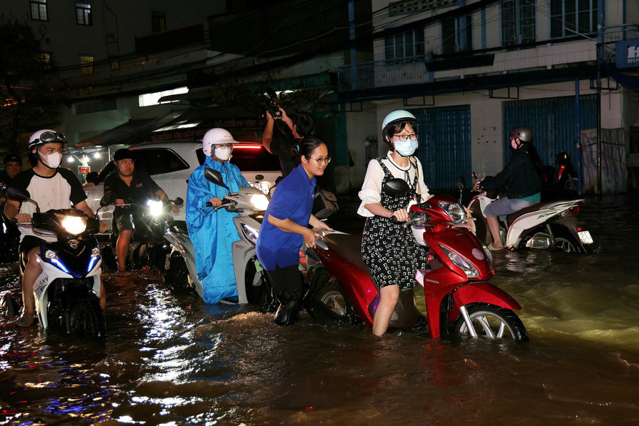 Em Phạm Thảo Trang (áo xanh), sinh viên Trường Đại học Nam Cần Thơ cho biết, triều cường dâng cao vào đúng giờ tan tầm, kết hợp với mưa lớn gây ngập nhiều tuyến đường gần khu vực em đang sinh sống. Chứng kiến cảnh người dân điều khiển phương tiện khó khăn, em đã ra sức hỗ trợ, đẩy xe giúp mọi người vượt qua được các đoạn nước sâu. dinh-trieu-lich-su-17.jpg